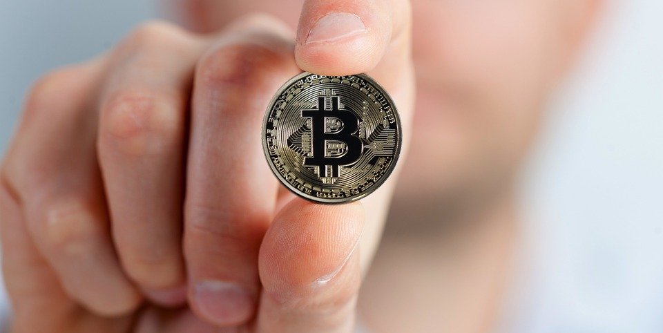 Bitcoin Münze in der Hand halten